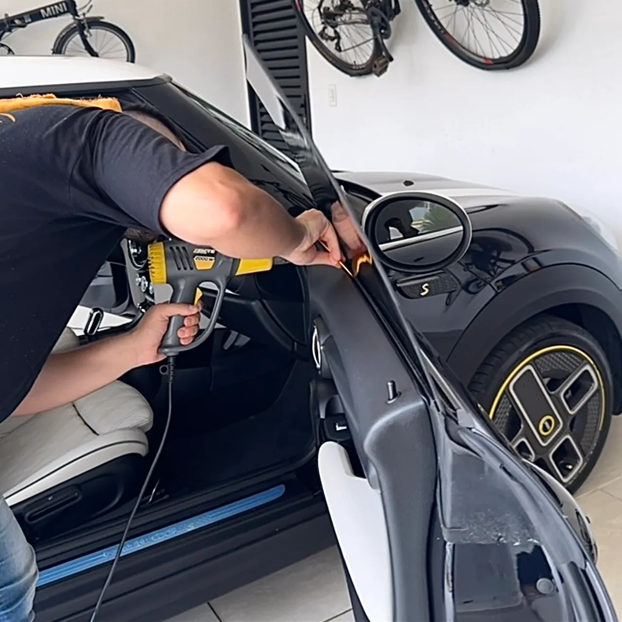 Técnico da RV Window Film aquecendo a película com o soprador na porta de um carro